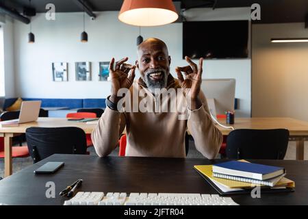 Portrait of african american mature businessman discussing on video call in office Stock Photo