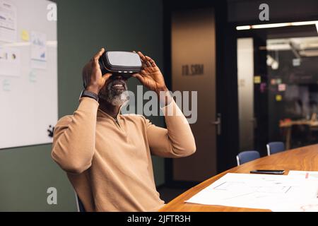 Mature african american businessman using virtual reality simulator at office Stock Photo