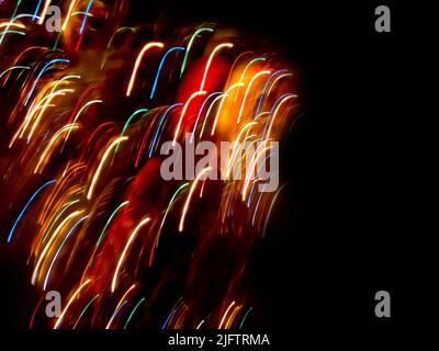 Neon light rays flash and glow on black. Light streaks electric color on black background. Stock Photo