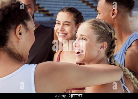 Diverse group of athletes standing together and smiling after practice. Young, happy, fit, active people bonding after training in sports centre Stock Photo