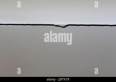 A Crack on the wall corner. The glue on the corner tiles are released and the crack appears Stock Photo