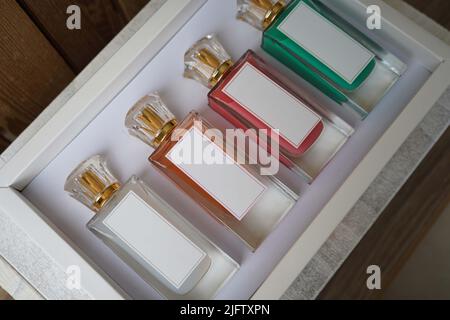 Perfume glass bottle mockup, blank cosmetic bottles on a box template. with different bottles colors red,white, orange and green perfume. Stock Photo