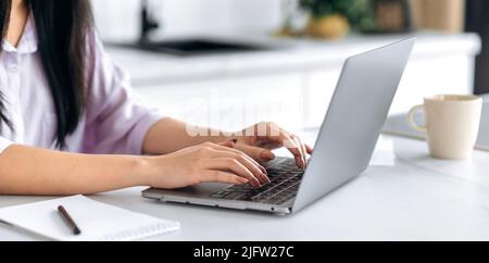 Close-up of female hands typing on laptop keyboard. Young woman using laptop for chatting online, texting with clients, write response e-mail, browsing internet. Wireless technology concept Stock Photo