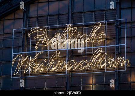 neon lettering in german merry christmas on a glass facade Stock Photo