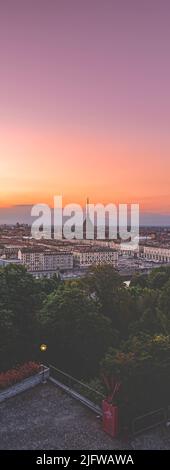 Turin, Italy. Panoramic view of the city in the evening after sunset. Skyline with the Mole in the evening. Banner vertical. July 1, 2022. Stock Photo