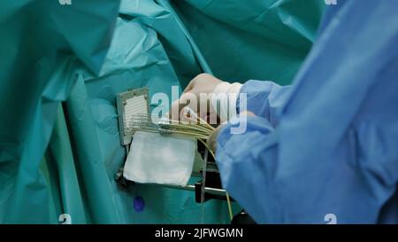 Assembly of equipment.Creative. Specially trained people in green coats specially assemble equipment with needles at the factory. High quality 4k foot Stock Photo