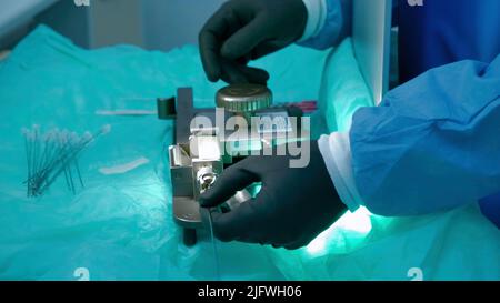 Assembly of equipment.Creative. Specially trained people in green coats specially assemble equipment with needles at the factory. High quality 4k foot Stock Photo