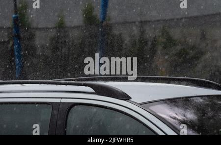 Car in the rain. Close-up of raindrops falling on a passenger car. Stock Photo