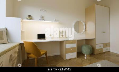 A spacious white room with a work space. Creative . A brightly lit room with a brown armchair and laptop, decorated with toys and a hanging mirror, an Stock Photo