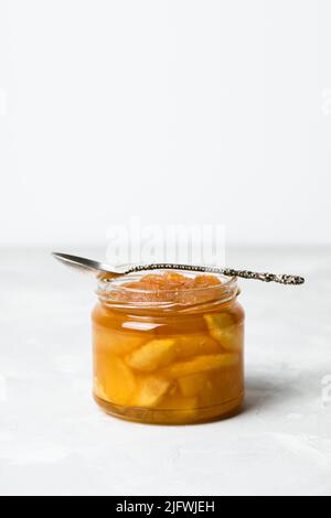 Apple jam in a jar with a spoon on a white background Stock Photo