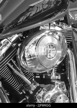 Closeup of metallic motorcycle engine details. A classic, shiny chrome motorbike engine at a motorcycle repair shop. Zoom in on a silver design, black Stock Photo