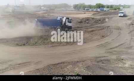 Yekaterinburg, Russia - August, 2021: Top view of moving dump truck on quarry site. Scene. Dump truck goes through earthen territory for construction. Stock Photo