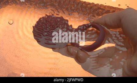 A small body massager. Creative. A small red massager that is placed in the water and turned on and the water begins to boil. High quality 4k footage Stock Photo