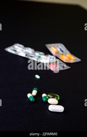 blister packs and medicial pills scattered on a black table Stock Photo