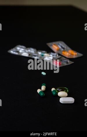 blister packs and medicial pills scattered on a black table Stock Photo