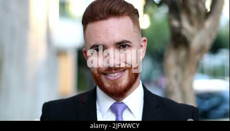 Handsome executive business man smiling to camera, irish redhead looking male standing outside Stock Photo