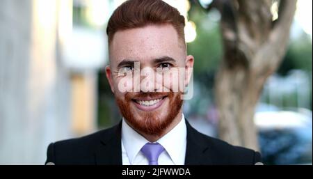 Handsome executive business man smiling to camera, irish redhead looking male standing outside Stock Photo