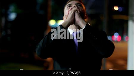Happy business man walking at night in city celebrating success raising fist cheering Stock Photo