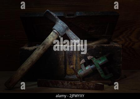 Hammer pick and vise. Construction and turning tools. Composition in a low key. Vintage still life. Front view. Stock Photo