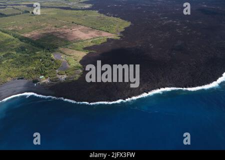Lava Field. The fissure 8 lava flows of K?lauea's 2018 lower East Rift Zone eruption meet the ocean at Pohoiki Bay, Hawaii, USA,  in the lower left corner of this image. Wave erosion of the 2018 lava flows along the coast contributes to sand accumulation that forms a beach at Pohoiki Bay.  Credit K.Mulliken/USGS Stock Photo