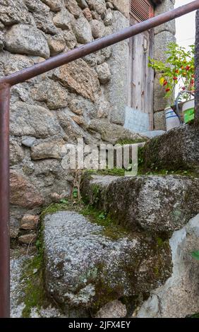 Mossy granite stairs leading to the front door of an old traditional house in a village (Sao Paio) in Serra da Estrela, Portugal. Stock Photo