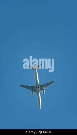 Warsaw, Poland - June 26, 2022: Passenger line airplane over blue sky, view from the ground. Travel by plane. Stock Photo