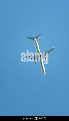 Warsaw, Poland - June 26, 2022: Passenger line airplane over blue sky, view from the ground. Travel by plane. Stock Photo