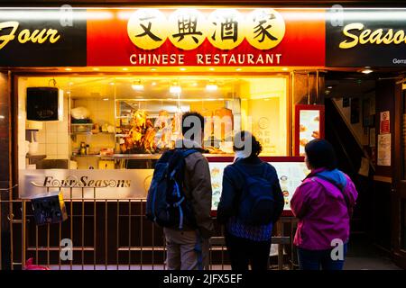 Showcase of a restaurant in Chinatown with crispy ducks hanging. Chinatown is an ethnic enclave in the City of Westminster. The enclave currently occu Stock Photo