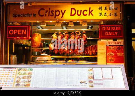 Showcase of a restaurant in Chinatown with crispy ducks hanging. Chinatown is an ethnic enclave in the City of Westminster. The enclave currently occu Stock Photo