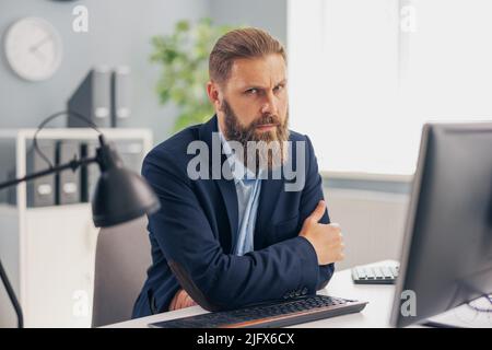Pensive man working in office Stock Photo
