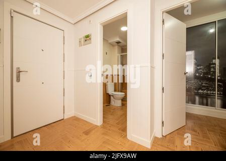 Entrance hall and distributor of a house with ceramic stoneware floors similar to wood and entrance to several rooms Stock Photo