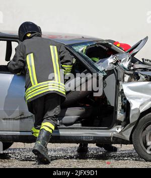 fire brigade team in action during the rescue of the injured person after the car accident Stock Photo