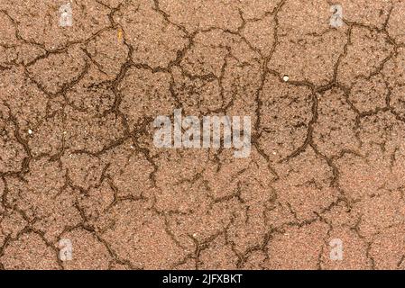 Cement background of reddish color with cracks, roughness and textures. Stock Photo