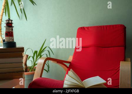 open book on a red armchair Stock Photo