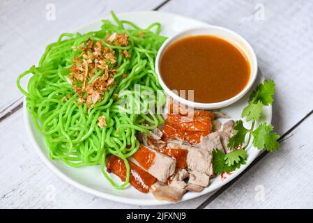 Jade noodle Asian Thailand food , roasted duck with jade noodle on white plate and duck sauce, green noodles Chinese food Stock Photo