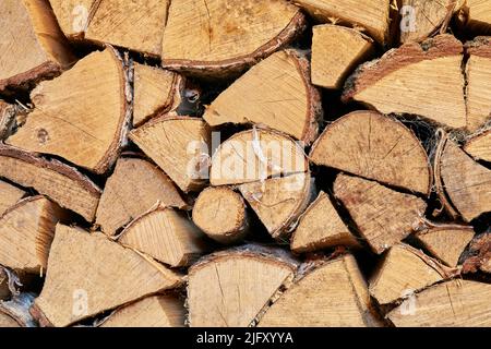 Above view of chopped firewood, logs stacked together in storage pile. Closeup of wooden background and texture. Collecting dry rustic wood as a Stock Photo