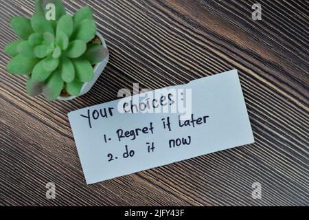 Concept of your choices - regret it later or do it now write on sticky notes isolated on Wooden Table. Stock Photo