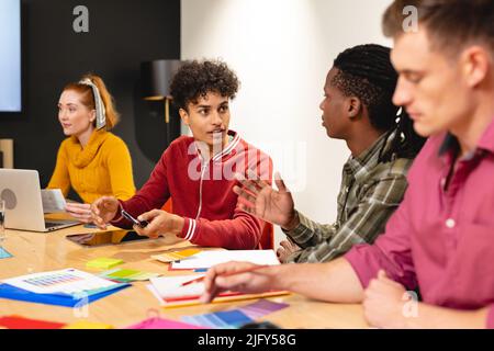 Biracial app developer discussing ideas with african american colleague in meeting at office Stock Photo