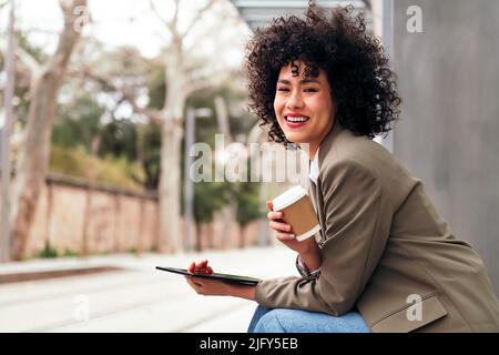 woman drinking coffee while waiting for the bus Stock Photo