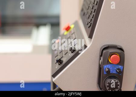 Handheld remote controller and operator console of metalworking CNC machining center. Selective focus. Stock Photo