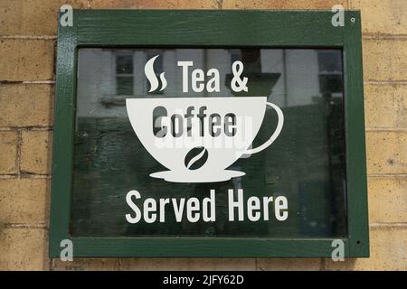Green tea and coffee served here sign hanging on a wall at knaresborough railway station North Yorkshire, UK Stock Photo