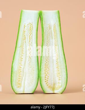 Two halves of one zucchini, or courgette longitudinally cut in the middle. Fresh vegetable or relationship concept Stock Photo