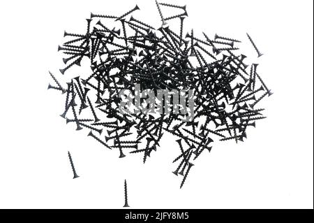 Black construction screws on wood on a white isolated background Stock Photo