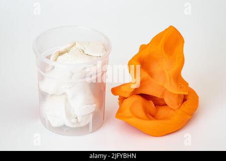 Orange colorful play dough for kids on white background. Children creativity and modeling clay Stock Photo
