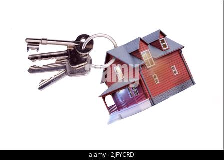 Toy house on keyring with keys to a home isolated on a white background. Concept for house sales, home ownership, estate agents, house insurance and b Stock Photo