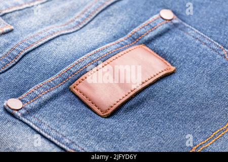 Close up empty brown leather tag on back pocket of new men blue denim shorts Stock Photo