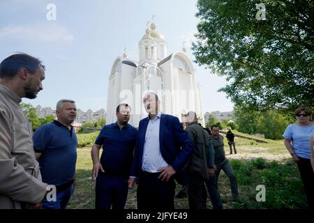 Taoiseach Micheal Martin with local officials outside the church of St Andrew the First Called in Bucha, where a mass grave was used by Ukrainians to bury neighbours they claim were killed at the hands of Russian armed forces during the invasion of Ukraine. Picture date: Wednesday July 6, 2022. Stock Photo