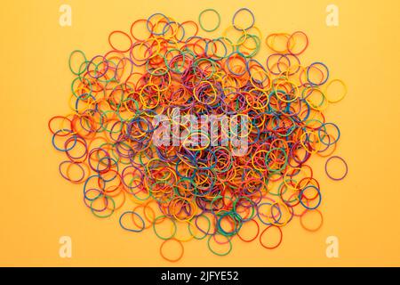 Top view Elastic band rubber, multicolor rubber bands on yellow backgrounds Stock Photo