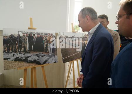 Taoiseach Micheal Martin views an exhibition of photographs depicting the mass grave, on display at the church of St Andrew the First Called in Bucha, as the premier visits Ukraine to reiterate Irish solidarity with the Ukrainian authorities in the face of the Russian invasion. Picture date: Wednesday July 6, 2022. Stock Photo