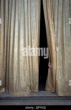 Suggestive man's hand opening golden theater Stock Photo